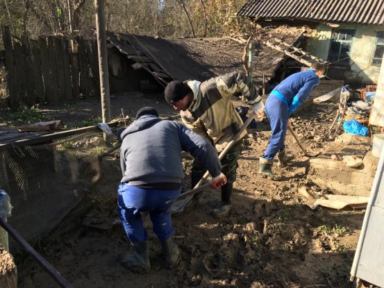 Добровольцы из Новокубанска расчищают от ила подворья пострадавших от наводнения.